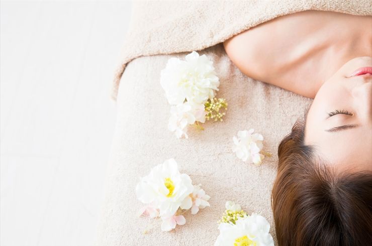 施術を受ける女性と花